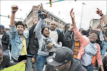  ?? JIM LO SCALZO/EPA ?? Baltimore residents cheer after hearing Friday that six police officers would be charged in the death of Freddie Gray.