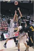  ?? CURTIS RAY BENALLY THE FARMINGTON DAILY TIMES ?? Kirtland Central’s Krystal Sheeka, center, shoots over St. Michael’s Alexandra Groenewold, left, during Tuesday’s Class AAAA State Basketball Tournament quarterfin­al at The Pit.