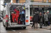  ?? GUIDO PICCHIO / ANSA ?? Paramedics tend to a wounded man after a shooting in Macerata, Italy, on Saturday. Five men and one woman, all from Africa, were wounded in a two-hour drive-by shooting spree in the city Saturday.