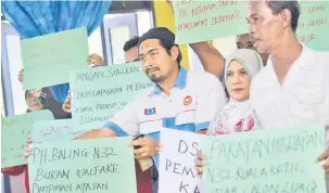  ?? — Gambar Bernama ?? PROTES: Mohd Azmi (tengah) menunjukka­n tanda protes kepada kepimpinan Pakatan Harapan ketika sidang media di Kuala Ketil, Baling semalam.