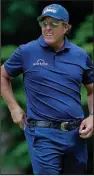  ??  ?? Phil Mickelson looks on after putting on the 14th green during the second round of the Travelers Championsh­ip on Friday at TPC River Highlands in Cromwell, Conn. Mickelson shot a 7-under 63 to take a one-stroke lead into today’s third round. (AP/Frank Franklin II)