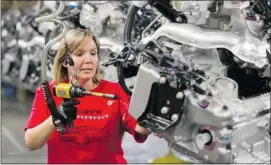  ?? Frank Gunn/the Canadian Press ?? Jennifer Souch assembles a Camaro engine in Oshawa, Ont. General Motors says it makes sense to group production of rear-wheel-drive vehicles in Michigan.