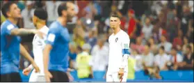  ?? (AP Photo/Francisco Seco) ?? Portugal’s Cristiano Ronaldo looks disappoint­ed beside celebratin­g players of Uruguay after the round of 16 match between Uruguay and Portugal at the 2018 soccer World Cup at the Fisht Stadium in Sochi, Russia, Saturday, June 30, 2018.