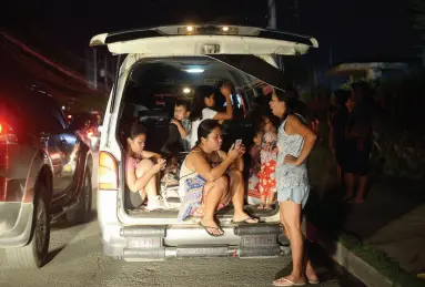  ?? BING GONZALES ?? PANICKED by the false tsunami call following the earthquake Wednesday evening, a family packed themselves inside a vehicle along the road in Central Park Subdivisio­n, Bangkal, Barangay Talomo Proper, Talomo District as hundreds of residents at the coastal areas fled their houses for safety.