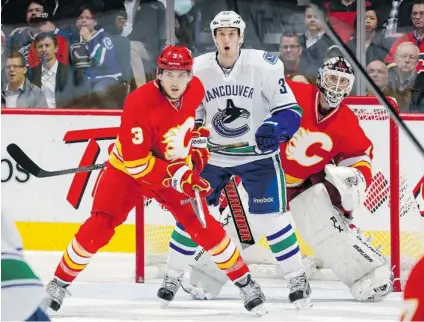  ?? GERRY THOMAS/ NHLI VIA GETTY IMAGES ?? Defenceman Brett Carson and goaltender Miikka Kiprusoff of the Calgary Flames try to keep tabs on towering forward Dale Weise of the Vancouver Canucks during Wednesday’s NHL game at the Scotiabank Saddledome in Calgary. The Canucks opened a five- game...