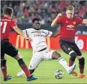  ?? Robyn Beck AFP/Getty Images ?? MANCHESTER UNITED’S Ander Herrera and Scott McTominay battle AC Milan’s Franck Kessie.
