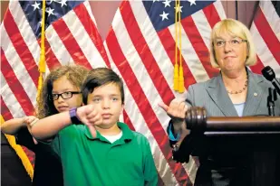  ?? TOM BRENNER/THE NEW YORK TIMES ?? Children with pre-existing health conditions covered by the Affordable Care Act signal a thumbsdown as Sen. Patty Murray, D-Wash., looks on in July in Washington.
