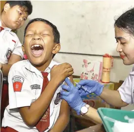  ?? DIPTA WAHTU/JAWA POS ?? SEMBUNYI DI KELAMBU: Bagi para siswa ini, suntik difteri adalah hal yang menakutkan. Beginilah berbagai ekspresi mereka saat program vaksinasi itu dilangsung­kan di SDN Kaliasin 1 Surabaya kemarin (5/2).