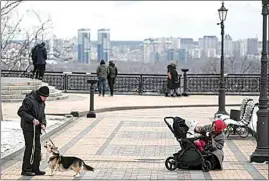  ?? ANDREW KRAVCHENKO / AP ?? People walk in downtown Kyiv, Ukraine on Sunday.