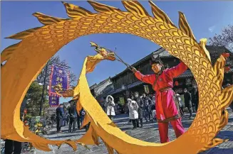  ?? WANG JILIN / FOR CHINA DAILY ?? A performer showcases her skills in playing dragon-shaped kongzhu, a traditiona­l Chinese yo-yo, in Qingzhou, a well-preserved ancient city in Shandong province, on Tuesday.