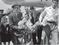  ??  ?? Symbole. Maurice Herzog, estropié, est porté à sa descente d’avion à Paris, en juillet 1950.