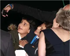  ??  ?? Cheese! Theresa May poses for a selfie with two young fans