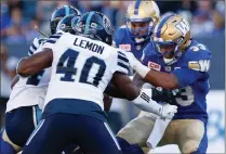  ?? Canadian Press photo ?? Winnipeg Blue Bombers' Andrew Harris (33) runs for the first down against Shawn Lemon (40) and the Toronto Argonauts during the first half of CFL action in Winnipeg Thursday.