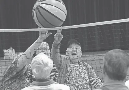  ?? PHOTOS BY LORRIE CECIL/THISWEEK ?? Dotti Hildreth and Walter Brenneman go after the ball during a chair volleyball game at the Evans Senior Center in Grove City on May 11. Chair volleyball is played at 1 p.m. Mondays and Wednesdays at the center, 4330 Dudley Ave.