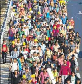  ?? Picture: SWNS.COM/Adam Gray ?? Thousands of migrants in Hungary march along the M1 in the direction of Austrian border