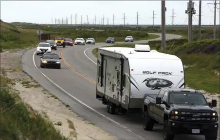  ?? STEVE EARLEY — THE VIRGINIAN-PILOT VIA AP ?? Vacationer­s head north on NC 12 on Hatteras Island, N.C., on Friday. An estimated 10,000 tourists face a noon deadline Friday for evacuating the island on North Carolina’s Outer Banks after a constructi­on company caused a power outage, leaving people...