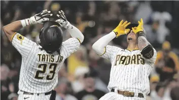  ?? AP PHOTO/GREGORY BULL ?? San Diego Padres’ Manny Machado, right, reacts with teammate Fernando Tatis Jr. (23) after hitting a two-run home run during the seventh inning of a baseball game against the Houston Astros, on Saturday in San Diego.