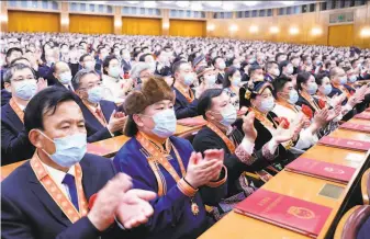  ?? Yan Yan / Xinhua News Agency ?? Attendees applaud during a ceremony to mark the official end of extreme poverty in China in Beijing. It comes at a time when China’s economy is growing again following the pandemic.