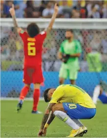  ?? THE ASSOCIATED PRESS PHOTOS ?? Brazil’s Neymar, front, reacts as Belgium’s Axel Witsel celebrates after Brazil was knocked out by Belgium’s 2-1 win in their World Cup quarterfin­al Friday in Kazan, Russia. Belgium will take on France in the semifinals Tuesday in St. Petersburg.