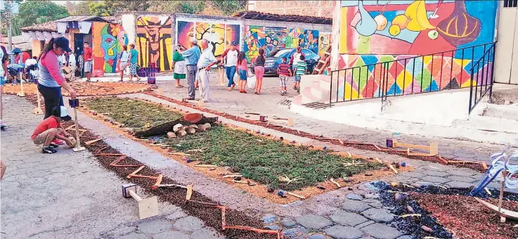  ??  ?? Arte religioso. Los miembros del grupo Jóvenes Unidos por la Paz de Chinameca se preparan para realizar una megaalfomb­ra que medirá 475 metros de largo, la cual estará en los barrios Dolores y San Juan.