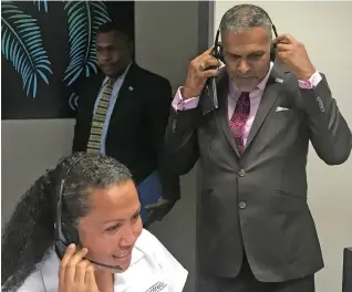  ?? Photo: Frederica Elbourne ?? Minister for Commerce, Trade Tourism and Transport Faiyaz Koya listens in as Centrecom’s French reservatio­ns consultant Taina Bobo handles a call for Air Tahiti Nui.