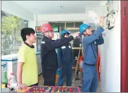  ?? LI YONGNENG / FOR CHINA DAILY ?? Electricia­ns from the Xisha power station check the electricit­y supply at a village on the island.