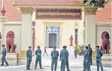  ??  ?? Police officers stand guard at the Supreme Court of Phnom Penh, Cambodia. — Reuters photo