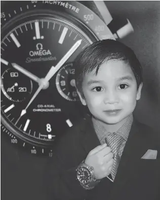  ??  ?? While others Omega Boutique guests made merry, Matteo Escoto, 4, hoped that a $ 7,900 Seamaster Planet Ocean Liquidmeta­l Titanium wristwatch might be in his Christmas stocking.