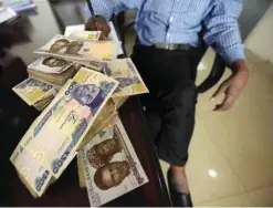  ??  ?? LAGOS: Naira banknotes, Nigeria’s currency, being counted at a money exchange outlet in Lagos. Nigeria’s central bank governor, Godwin Emefiele, dismissed calls to devalue the naira in his monetary policy committee statement. —AFP