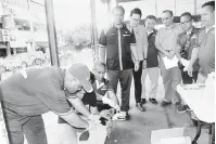  ??  ?? VAKSIN: Dr Abdul Rahman (berdiri, kiri) bersama Ladin, Robine dan Dr William melihat anjing diberi vaksin di Lawas semalam.