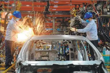  ?? Hoang Dinh Nam AFP/Getty Images ?? VIETNAMESE employees work at the Ford plant in Hai Duong province in 2017. Tariffs and retaliatio­n by U.S. trading partners have begun to negatively affect a growing swath of U.S. businesses at home and abroad.