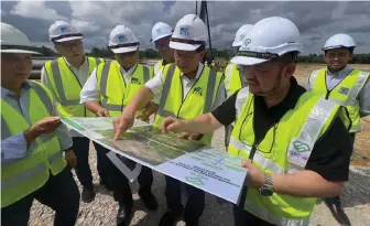  ?? — Photo by Roystein Emmor ?? Lee (second right) is briefed by Mazli (right) during his visit to the Rembus Depot site in Kota Samarahan.