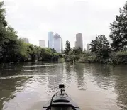  ?? Elizabeth Conley photos / Houston Chronicle ?? The Houston skyline appears in the distance during a trip down Buffalo Bayou with tour company Bayou City Adventures.