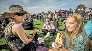  ?? LUZ ZUNIGA/NELSON MAIL ?? Mary Ann Wrigley, left, with granddaugh­ter Alysha Wrigley, right, and Stevie Chambers lap up the fare at the Motueka Kai Festival.