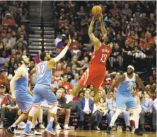  ?? Bob Levey / Getty Images ?? Houston’s James Harden shoots over Garrett Temple (17) and Kosta Koufos of Sacramento. Harden finished with 28 points.