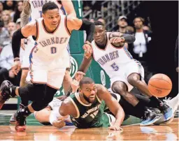  ?? CALVIN MATTHEIS / FOR THE MILWAUKEE JOURNAL SENTINEL CHARLES F. GARDNER MILWAUKEE JOURNAL SENTINEL ?? Thunder guard Russell Westbrook (left) goes after the ball as Bucks center Greg Monroe and Thunder guard Victor Oladipo get tied up. More at jsonline.com/bucks.