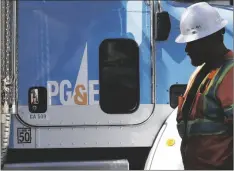  ?? AP PHOTO/JEFF CHIU ?? In this 2019 file photo, a Pacific Gas & Electric worker walks in front of a truck in San Francisco.