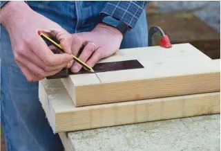  ??  ?? 2 Fix the base and roof timbers to your work bench using your clamp. Make a pencil mark 50mm from the timber’s edge, then draw a line 50mm down from the top edge. This is where the supporting post will go.