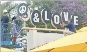  ?? Steve Hoegerman ?? ACTIVIST Rashelle Monet helps cover the Sambo’s sign at the Santa Barbara eatery with peace and love.