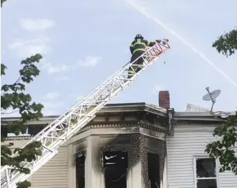  ?? NiCOLAuS CzARnECki / HERALD STAFF FiLE ?? HOSED? A firefighte­r works at a seven-alarm blaze in Southie last May. Firefighte­rs are dealing with ‘a lack of a plan’ to get vaccinated against coronaviru­s, the head of the statewide firefighte­rs’ union says.