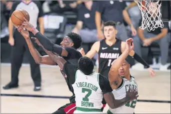  ?? MARK J. TERRILL — THE ASSOCIATED PRESS ?? Miami’s Bam Adebayo, left, battles for a rebound with Boston’s Jaylen Brown (7) and Grant Williams (12.. Adebayo scored 32 points and grabbed 14 rebounds to power the
Heat to the NBA Finals with a 125-113 victory over the Celtics Sunday night in Lake Buena Vista, Fla.