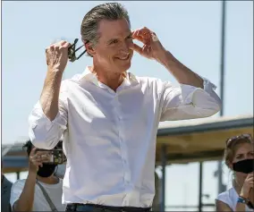  ?? AP PHOTO/DAMIAN DOVARGANES ?? In this Sept. 4, 2021, photo, California Gov. Gavin Newsom takes his face mask off before addressing hundreds of supporters at a campaign event against the California recall election at Culver City High School in Culver City, Calif. With a week to spare, the White House is diving into the California gubernator­ial recall election, coming to Democratic Gov. Gavin Newsom’s aid with visits from Vice President Kamala Harris and then with President Joe Biden himself to try to alleviate lingering concerns about Democratic turnout in the unusual September vote.