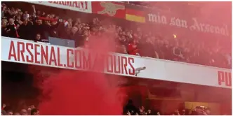  ?? GETTY IMAGES ?? Colour coded: a red smoke bomb is thrown into the Tottenham end