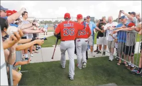  ?? Gerald Herbert / Associated Press ?? Fans reach out for autographs as Red Sox third baseman Eduardo Nunez (36) and Dustin Pedroia walk from one practice field to another during a recent workout. Spring training games got under way on Friday.