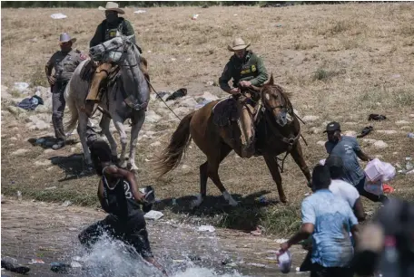  ?? Ap fiLE ?? CHASING ‘EM DOWN: U.S. Customs and Border Protection mounted officers attempt to contain migrants trying to cross the Rio Grande river from Ciudad Acuna, Mexico, into Del Rio, Texas, on Sept. 19.