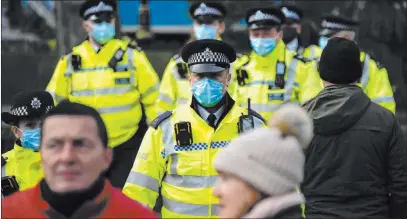  ?? Alberto Pezzali The Associated Press ?? Police officers wear face masks as they patrol an anti-lockdown demonstrat­ion Monday in London’s Parliament Square.