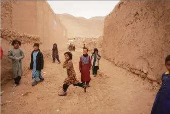  ?? Mstyslav Chernov / Associated Press ?? Afghan children play in Sang-e-Atash, a drought-stricken area where Red Crescent aid is the population’s only lifeline for the harsh winter. Thousands of families live in extreme poverty.