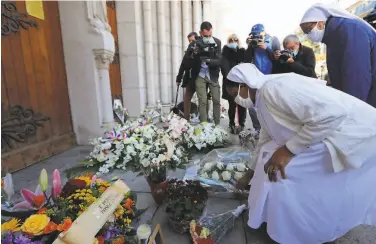  ?? Valery Hache / AFP via Getty Images ?? Nuns place flowers in front of the Notre Dame Basilica in Nice in tribute to the three stabbing victims.