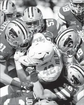  ?? Bo Rader TNS ?? TEXAS TIGHT END Caleb Blueitt is stopped by Kansas State defenders in the second quarter. The Longhorns offense struggled in the 24-21 loss.