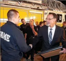  ?? PETE BANNAN – DIGITAL FIRST MEDIA ?? Fame firefighte­r Tom Stosser shakes hands with West Chester University President Chris Fiorentino after Fiorentino presented Fame Fire Company with a check for $50,000 as part of the company’s $2.5 million capital campaign Stosser is a senior at West...